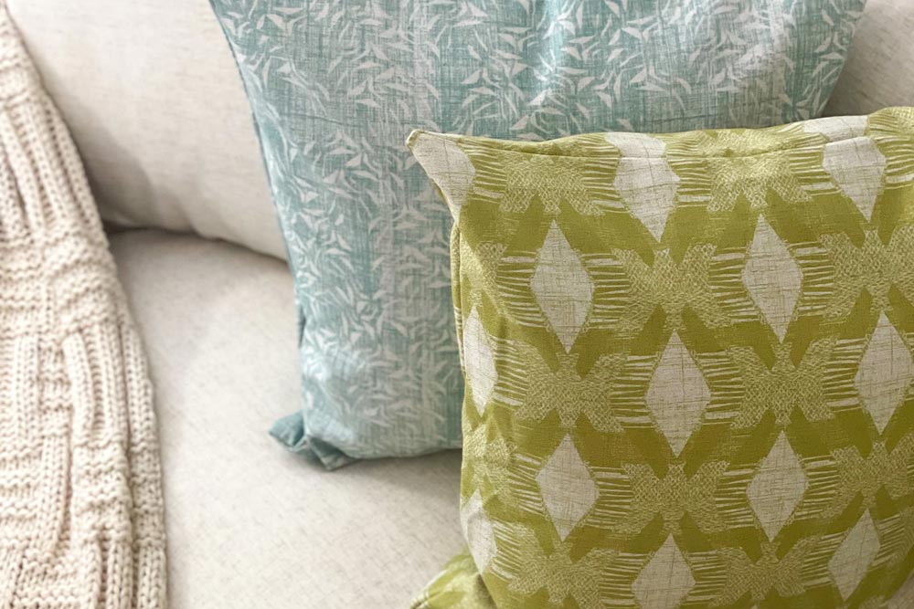 NOHO HOME Contract Residential Project Image Of Colorful Light Blue and Green Hawaiian Pillows On a Couch