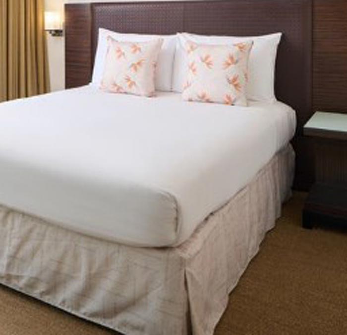 Contract Tan Hawaiian Print Bed Runner Skirt Around a Hotel Bed