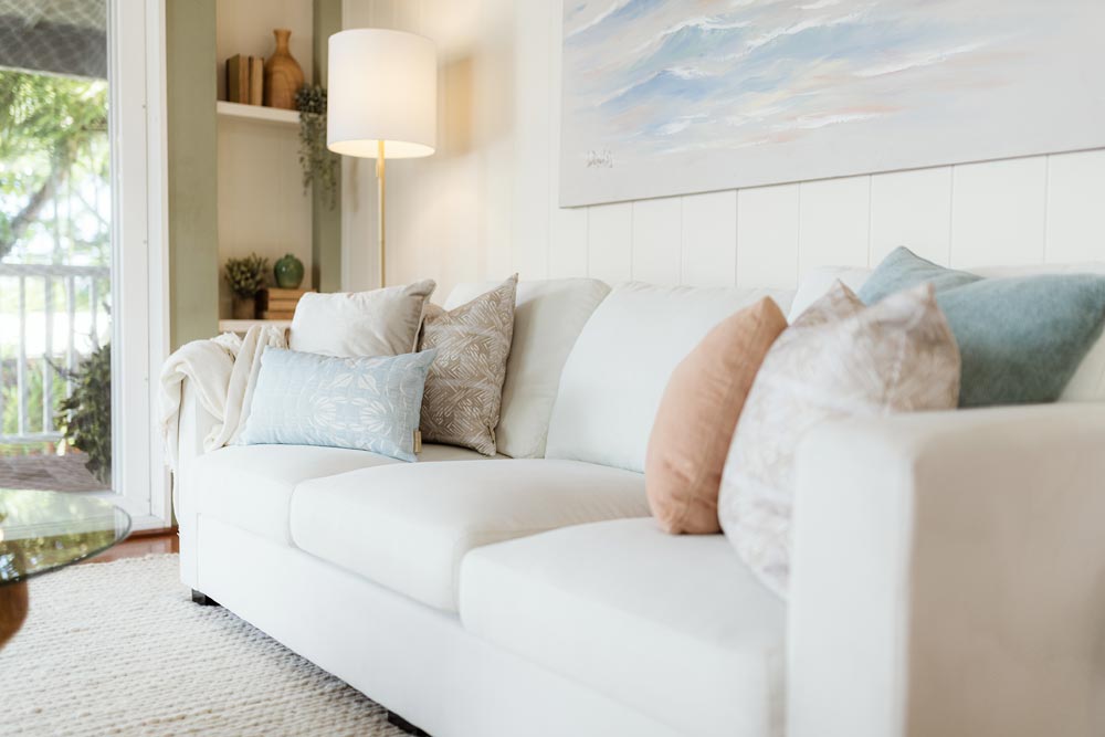 NOHO HOME Contract Residential Project Image Of Colorful Hawaiian Pillows On a White Couch